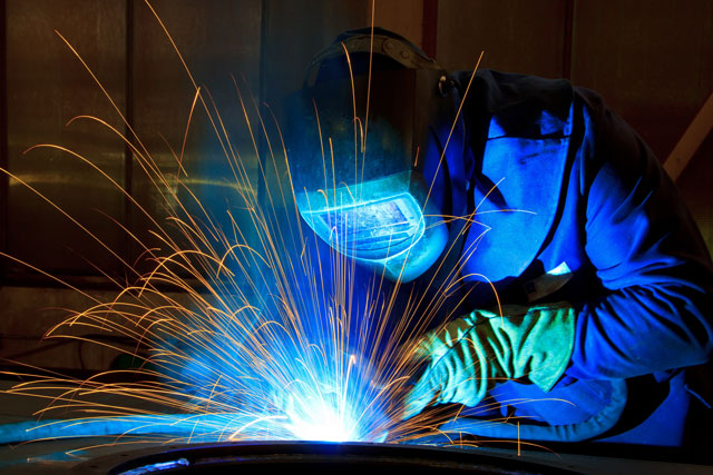 CWB certified welder at work with sparks